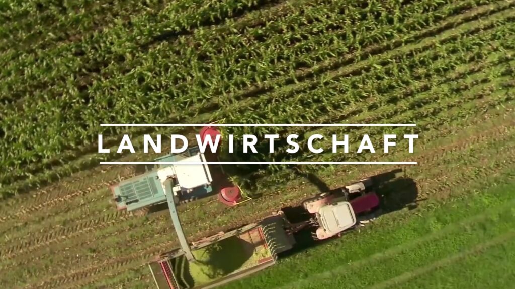 Screenshot aus dem Corporate Video von Liebherr mit dem Schriftzug Landwirtschaft über einem Traktor bei der Ernte